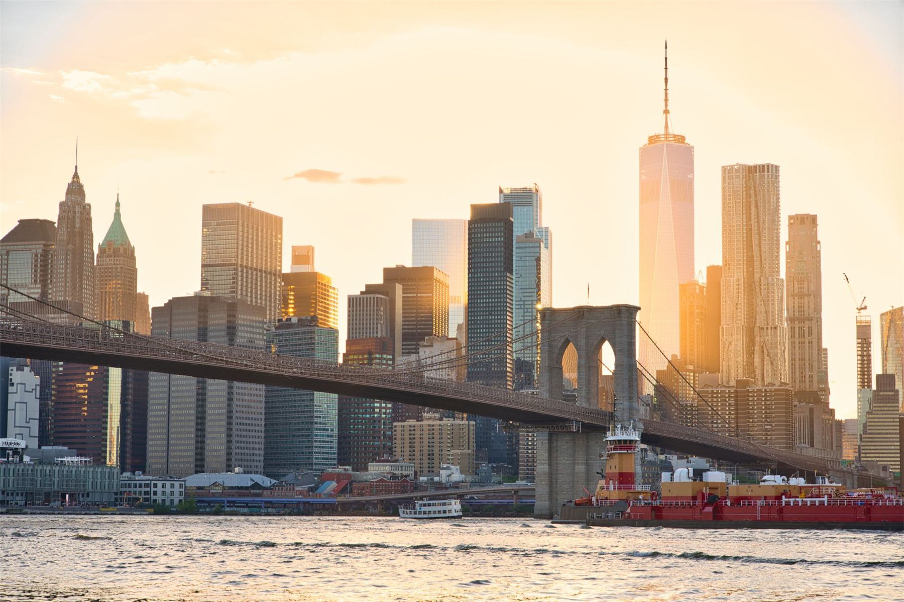 Lower Manhattan skyline and the Brooklyn Bridge glowing at sunset